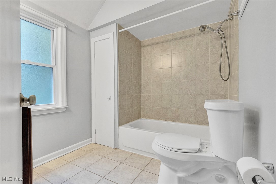 1195 Oxford Road Cleveland, OH 44121 - Photo 15 of 31 Full bathroom featuring light tile patterned flooring, bathtub / shower combination, and vaulted ceiling