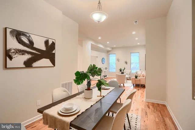 a view of a dining room with furniture a rug and wooden floor