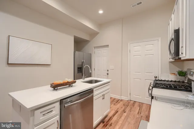 a kitchen that has a sink a stove and cabinets