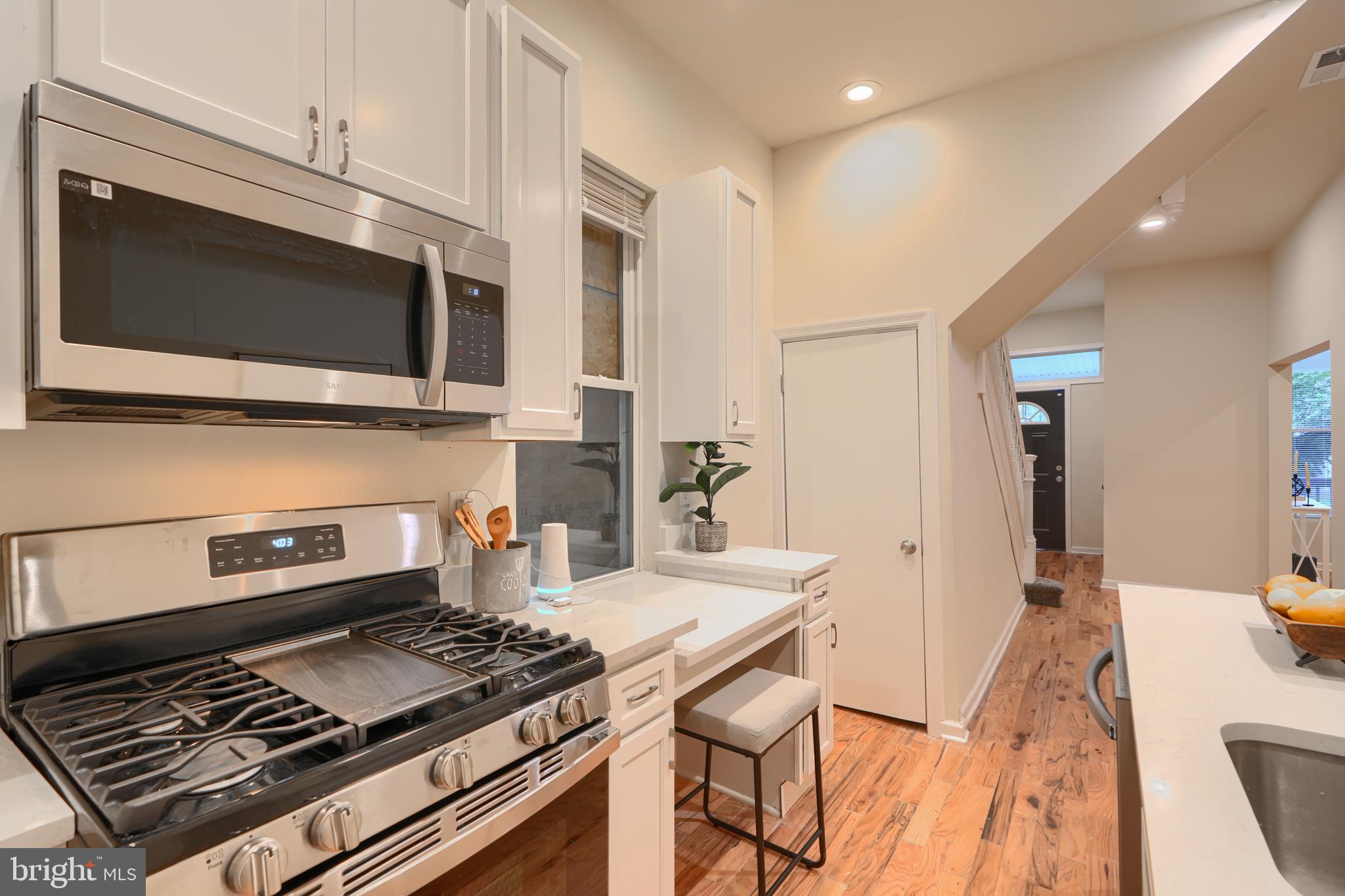 3308 Walbrook Avenue Baltimore, MD 21216 - Photo 13 of 32 a kitchen with a stove and a microwave