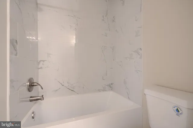 a white bath tub sitting next to a white sink and vanity
