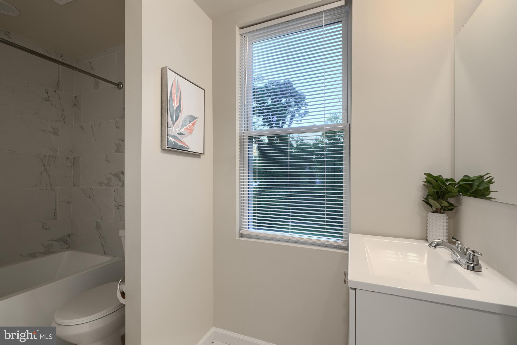 3308 Walbrook Avenue Baltimore, MD 21216 - Photo 20 of 32 a bathroom with a sink a toilet and shower