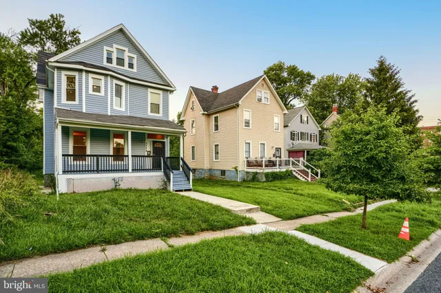 a front view of a house with a yard and trees