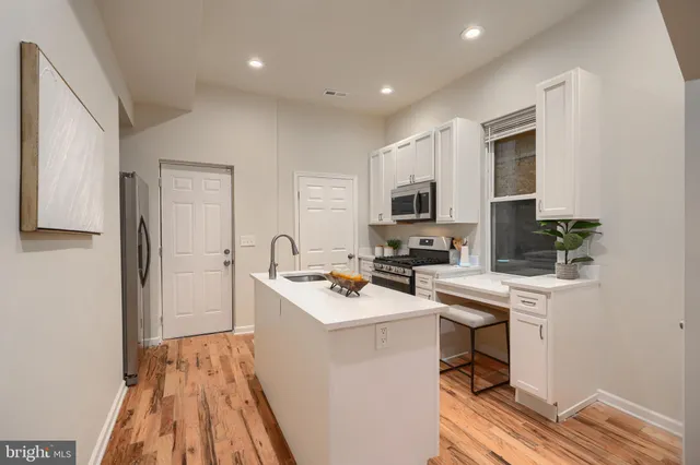 a kitchen with a sink a stove a microwave and wooden floor