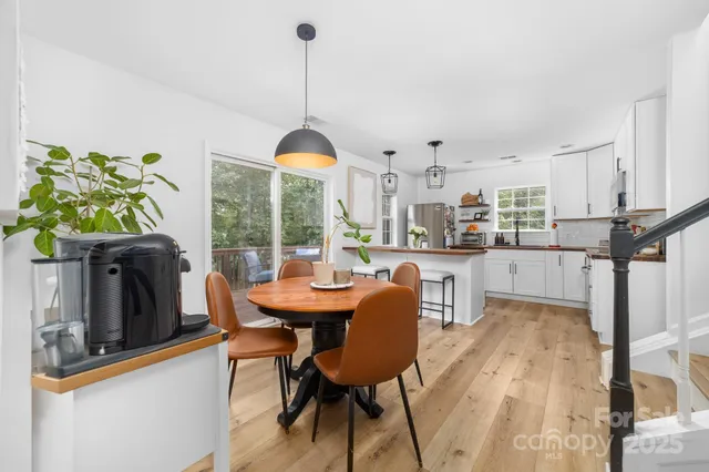a view of a dining room and livingroom with furniture wooden floor a chandelier