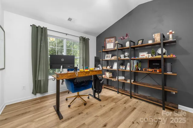 a view of a workspace with furniture and a window