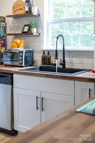 a kitchen with a sink and a stove next to a window