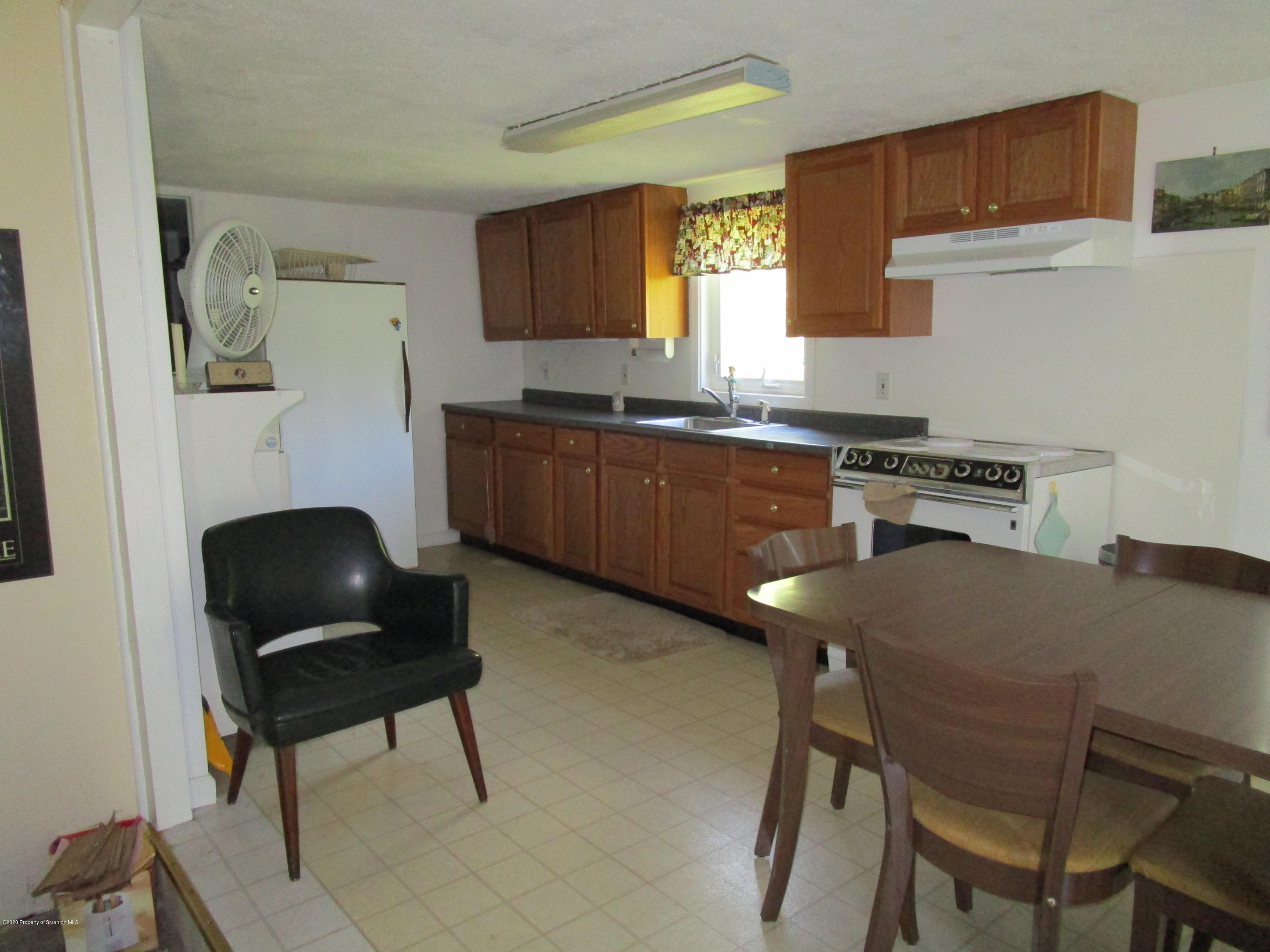 1815 Melrose Road Susquehanna, PA 18847 - Photo 3 of 11 a kitchen with a dining table chairs and a refrigerator