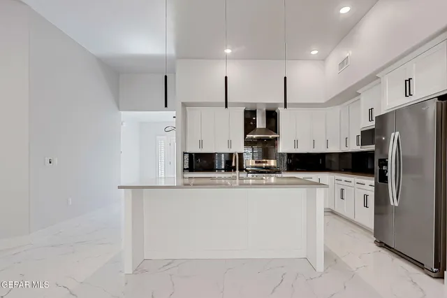 a kitchen with stainless steel appliances a refrigerator sink and microwave