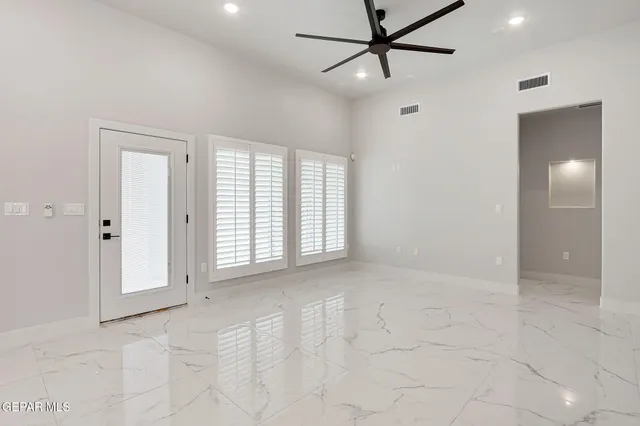 an empty room with fan and windows