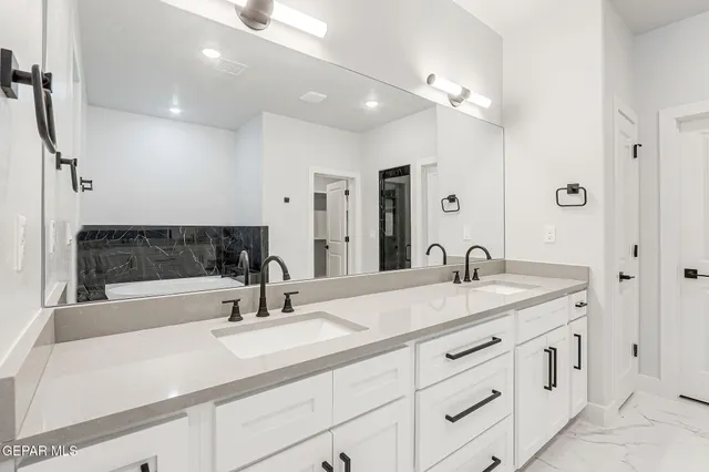 a bathroom with double sink and a mirror