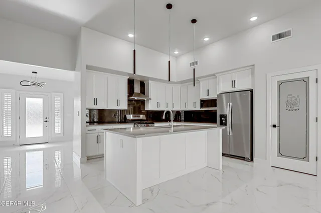 a kitchen with stainless steel appliances kitchen island granite countertop a refrigerator and a stove top oven