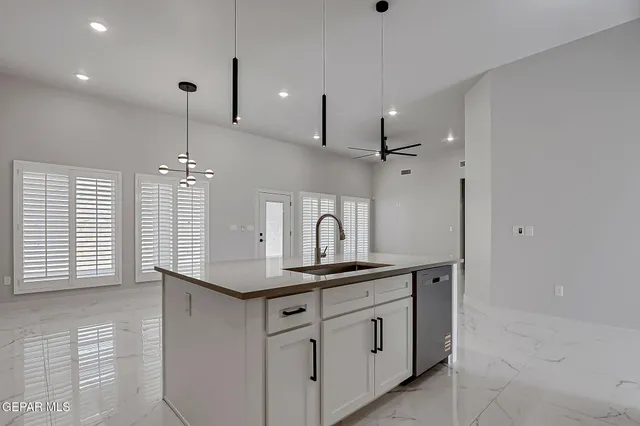a kitchen with white cabinets and sink