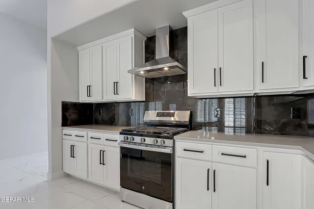 a kitchen with white cabinets and appliances