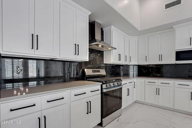 a kitchen with white cabinets and appliances