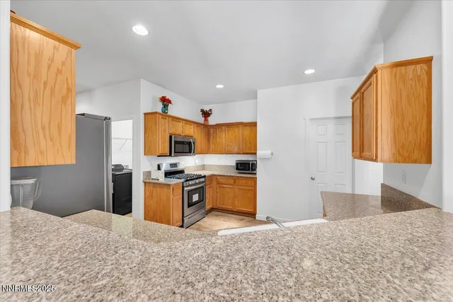 a kitchen with stainless steel appliances granite countertop a stove a sink and a refrigerator