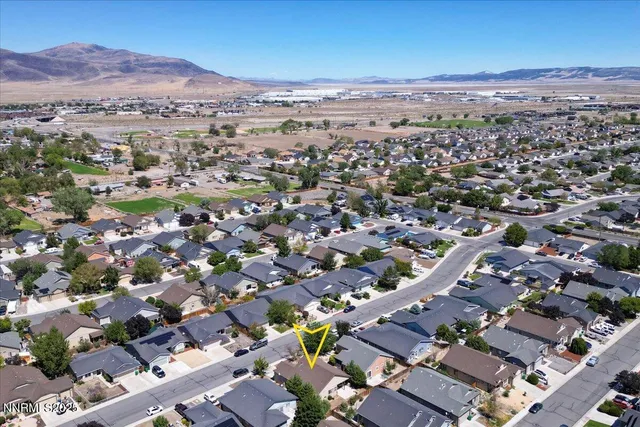 an aerial view of a city with lots of residential buildings and mountain view in back