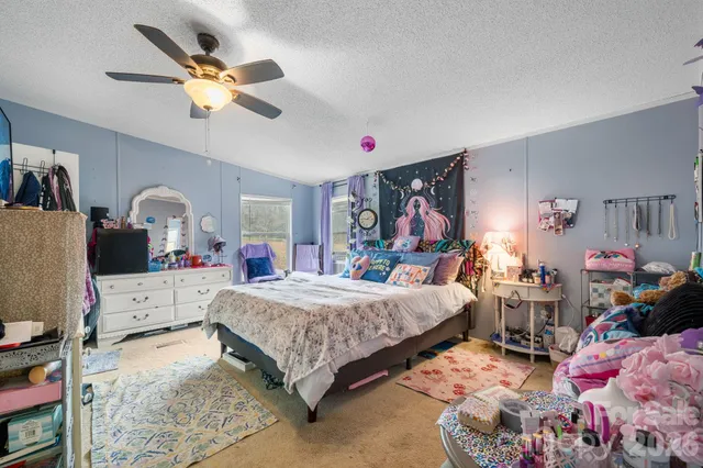 a bedroom with bed and a chandelier