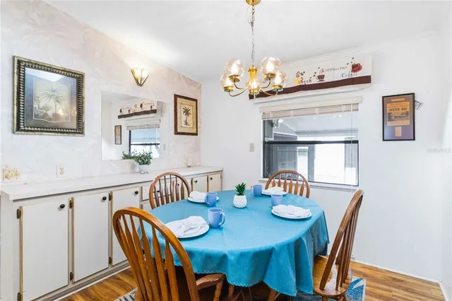 a view of a dining room with furniture a chandelier and wooden floor
