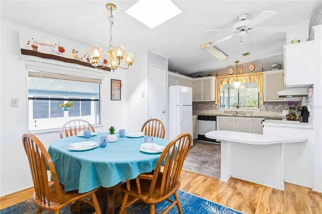 a dining room filled chandelier and wooden floor