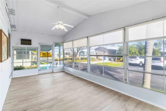 an empty room with wooden floor and floor to ceiling windows