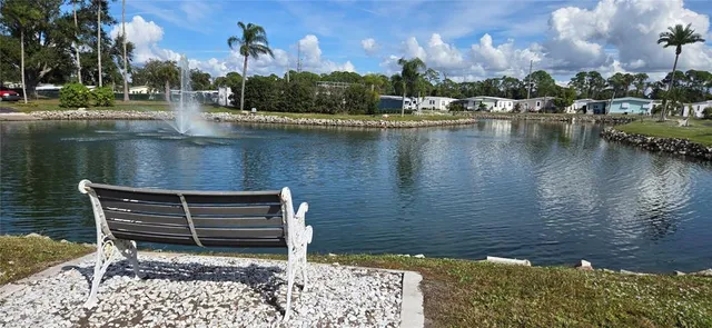 a view of a patio with table and chairs potted plants with floor to ceiling window and outdoor kitchen