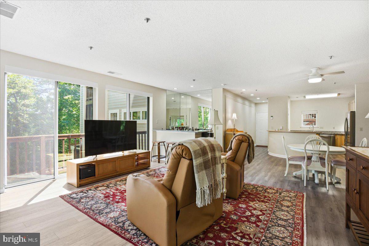 1126 Back Creek Loop, Unit 1126 Solomons, MD 20688 - Photo 23 of 47 a living room with furniture a flat screen tv and a floor to ceiling window