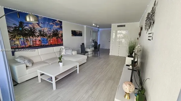 a living room with furniture and a painting on the wall