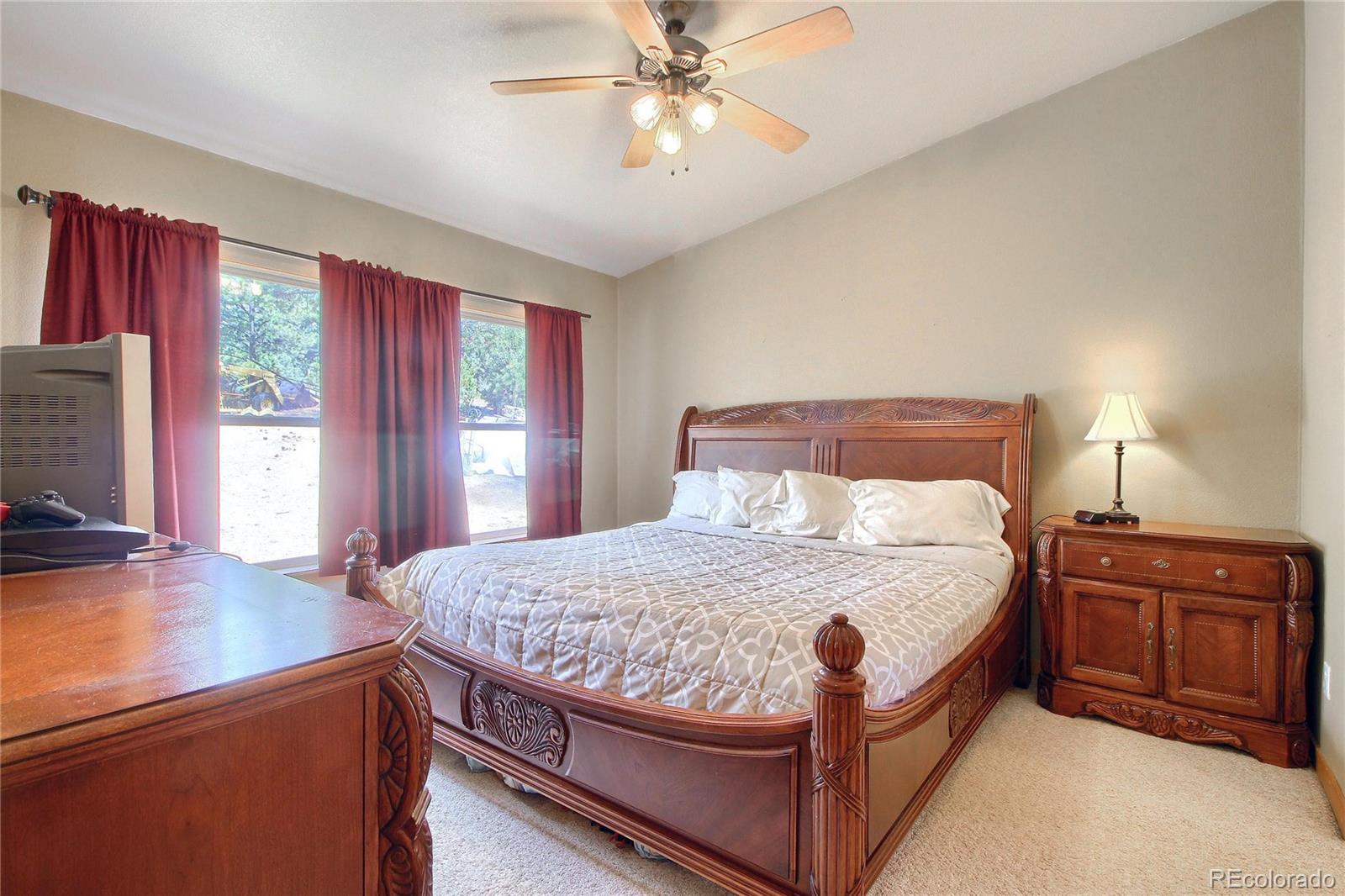 399 Buffum Street Bailey, CO 80421 - Photo 16 of 30 a bedroom with a bed and a chandelier
