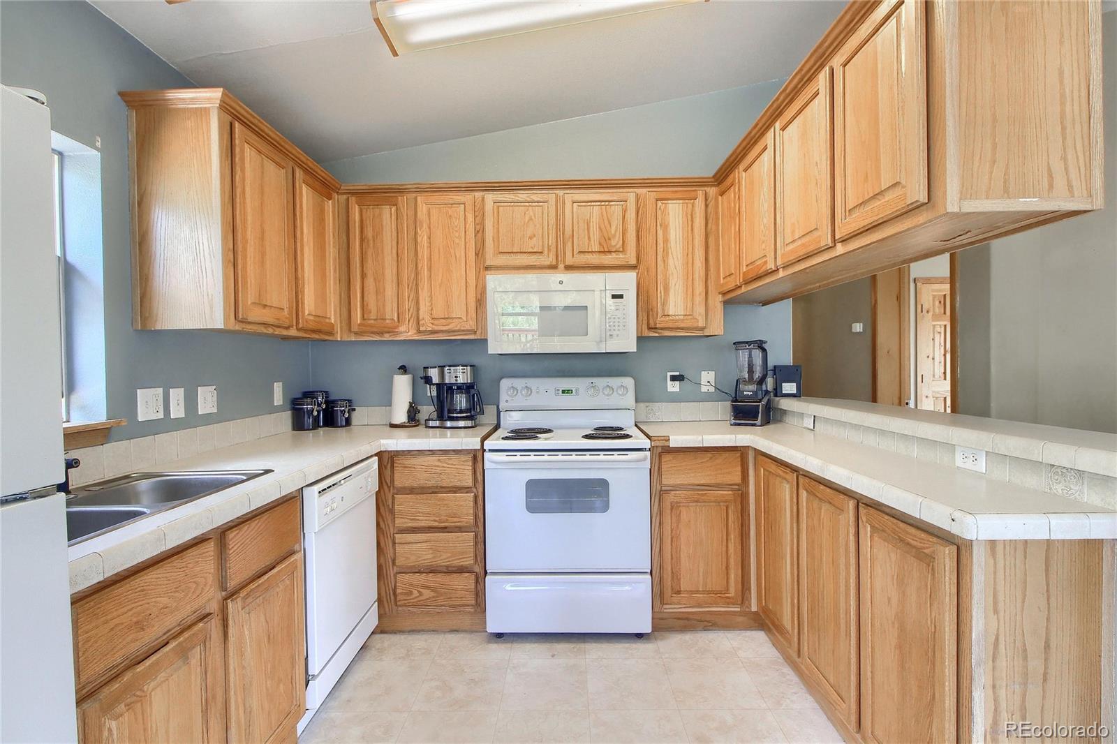 399 Buffum Street Bailey, CO 80421 - Photo 9 of 30 a kitchen with stainless steel appliances granite countertop a stove sink and cabinets