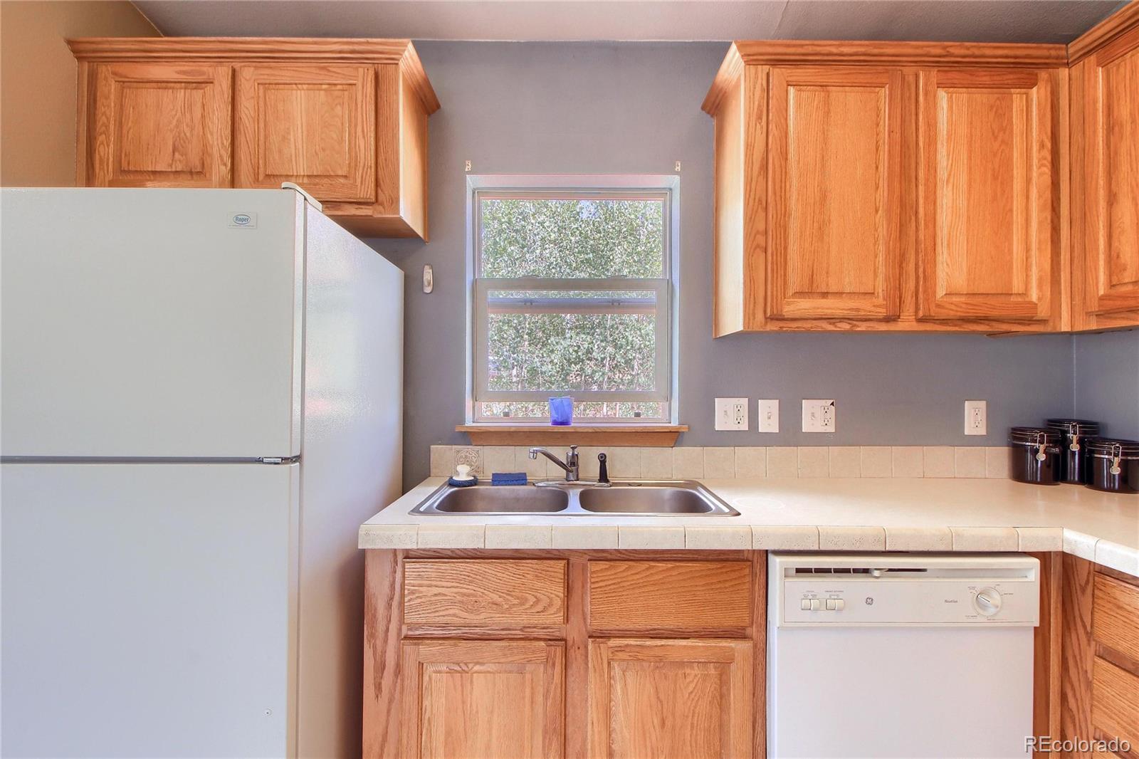 399 Buffum Street Bailey, CO 80421 - Photo 10 of 30 a kitchen with a white cabinets and a refrigerator