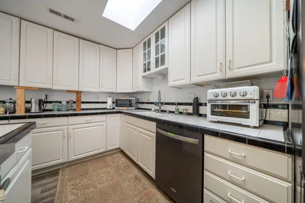 a kitchen with stainless steel appliances granite countertop a refrigerator and a stove top oven