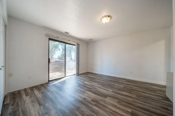 a view of empty room with wooden floor