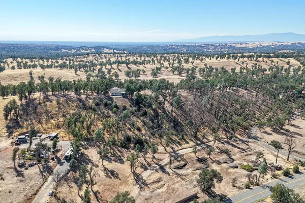 a front view of a house with a yard covered with snow and trees