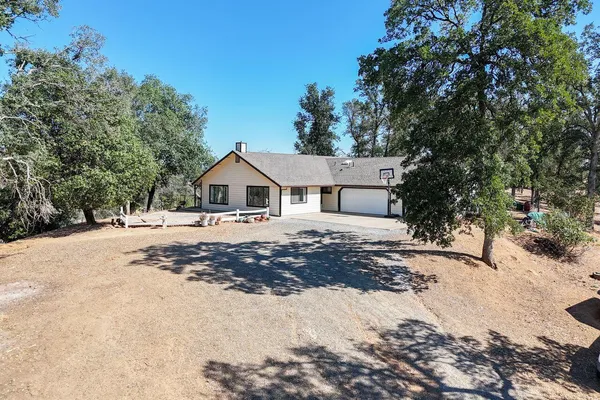 a view of a house with backyard and sitting area