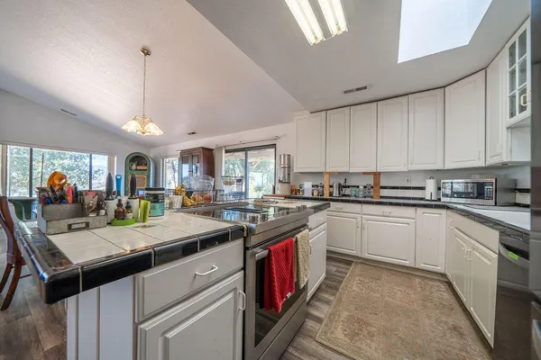 a kitchen with stainless steel appliances granite countertop a stove and cabinets