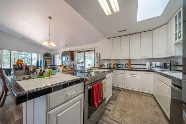 a kitchen with stainless steel appliances granite countertop a stove and cabinets