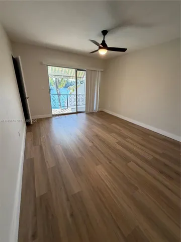 an empty room with wooden floor and door