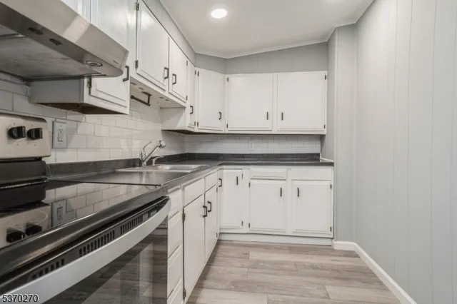 a kitchen with stainless steel appliances granite countertop a sink stove and cabinets