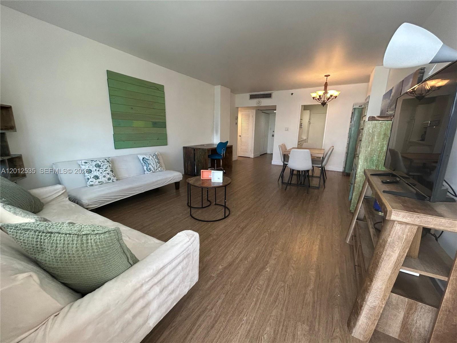 100 Lincoln Road, Unit 922 Miami Beach, FL 33139 - Photo 2 of 9 a living room with furniture and a flat screen tv