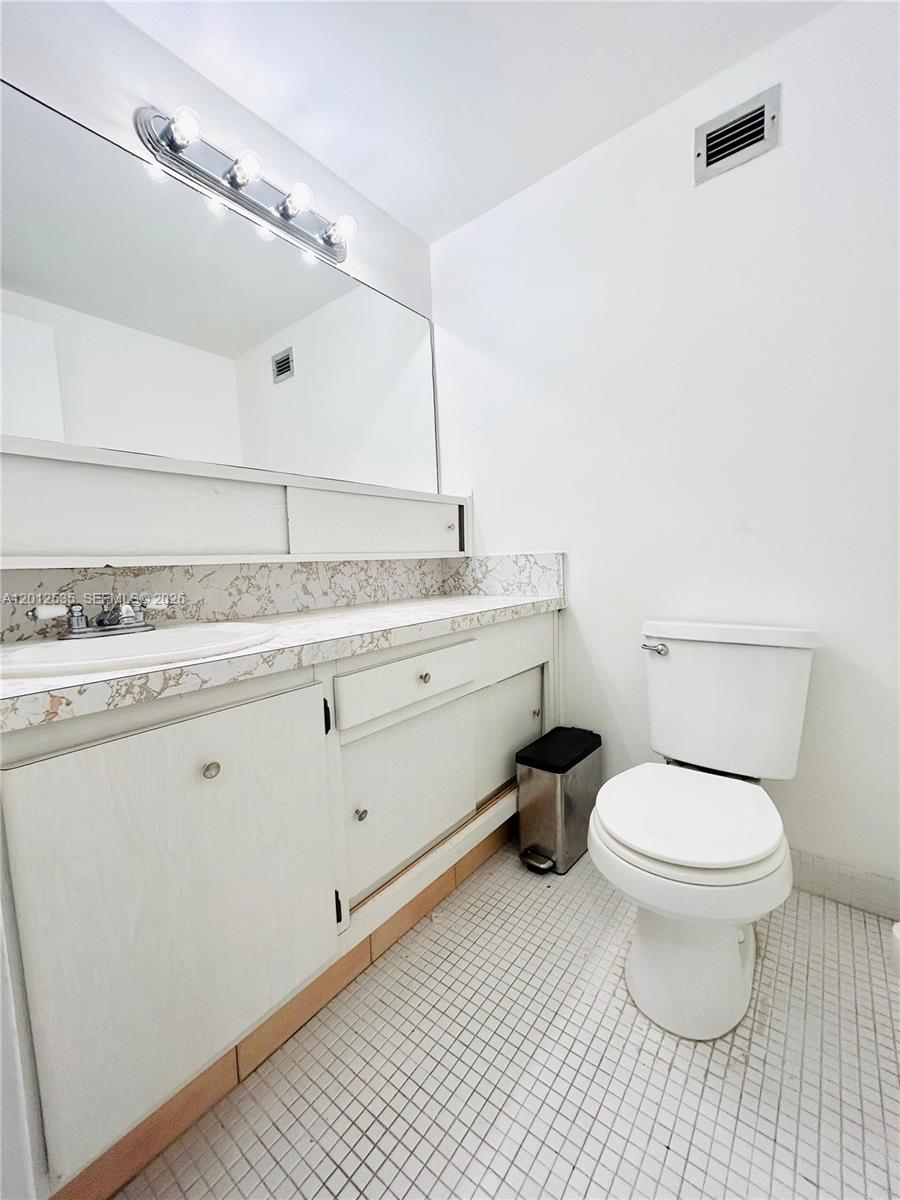 100 Lincoln Road, Unit 922 Miami Beach, FL 33139 - Photo 6 of 9 a bathroom with a granite countertop toilet sink and mirror