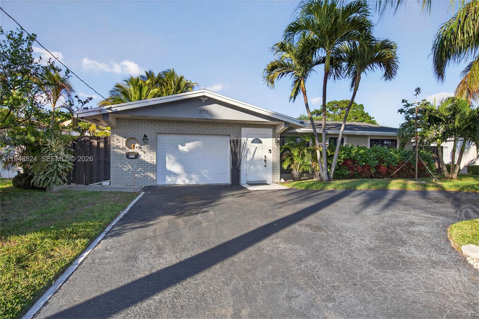 371 Southeast 3rd Street Pompano Beach, FL 33060 - Photo 16 of 87 a front view of a house with garden