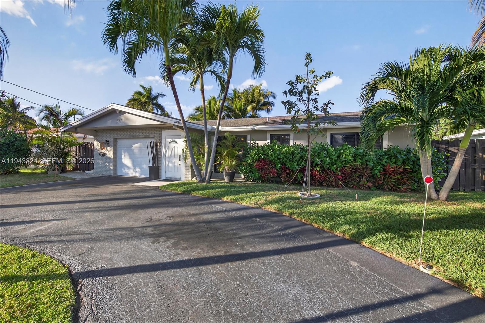 371 Southeast 3rd Street Pompano Beach, FL 33060 - Photo 18 of 87 a front view of a house with a yard and potted plants