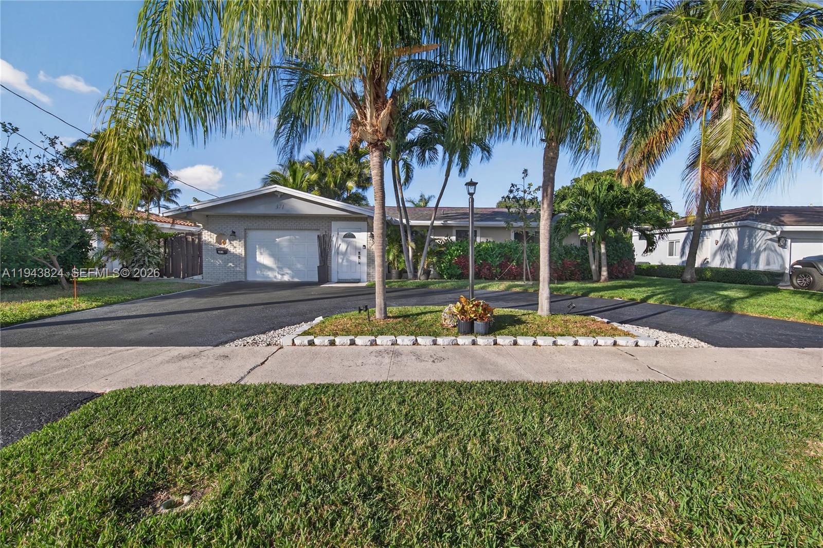 371 Southeast 3rd Street Pompano Beach, FL 33060 - Photo 19 of 87 a view of a white house with a big yard and palm trees