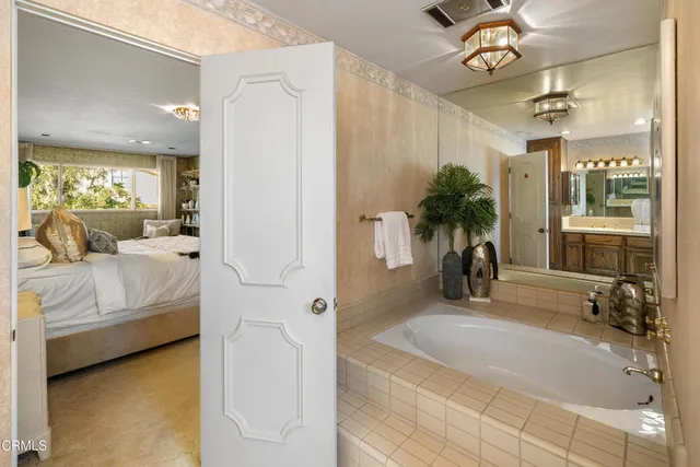 a bathroom with a tub sink and mirror