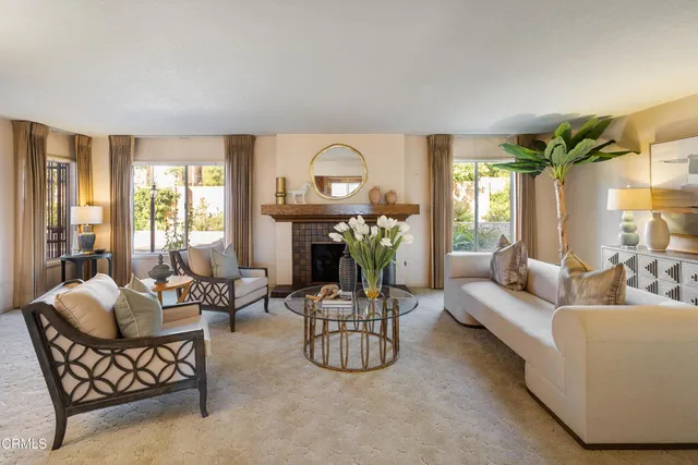 a living room with furniture a fireplace and a chandelier