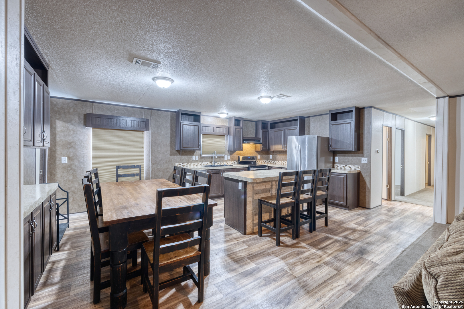 130 River Vly Road Rio Frio, TX 78879 - Photo 9 of 28 a kitchen with a dining table chairs and refrigerator