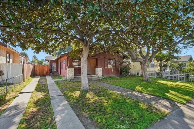 a front view of a house with a yard and trees