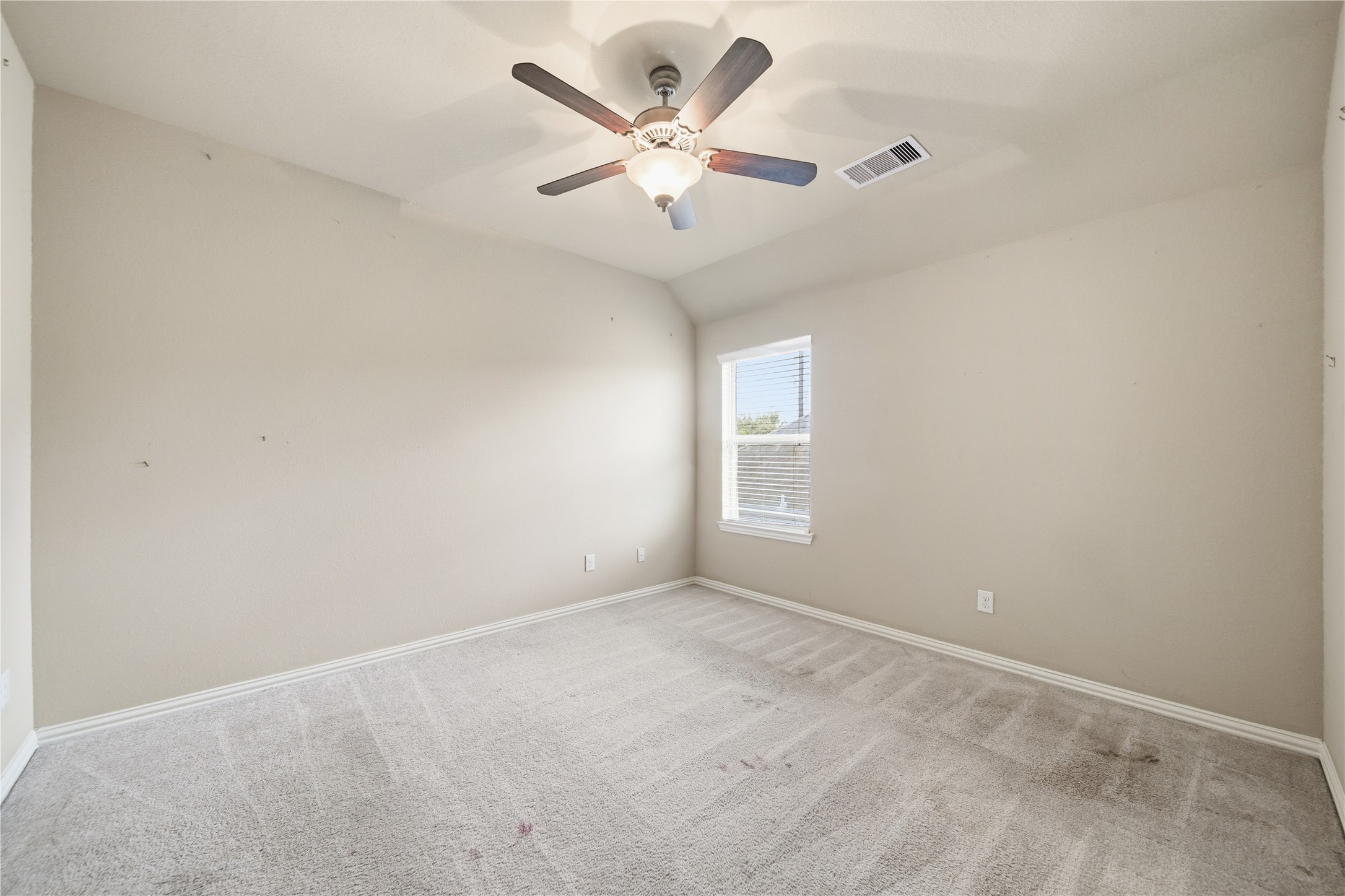 5303 Mesquite Willow Lane Rosharon, TX 77583 - Photo 29 of 32 This secondary bedroom features neutral walls and carpet, a central ceiling fan, and a window that allows natural light, creating a bright and cozy space.