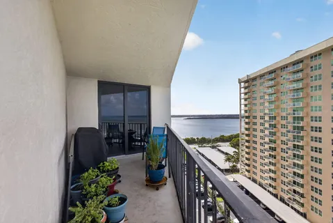 a kitchen with stainless steel appliances granite countertop a sink a stove a refrigerator cabinets and chairs